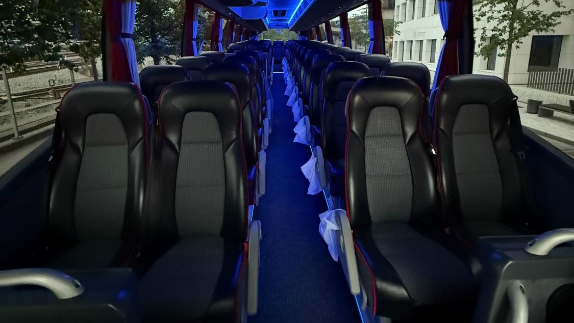 Komfortabelt bussinteriør med blått LED-lys i taket.